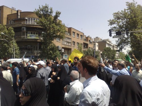 پرچم حزب اله در دست تعدادی از حامیان دولت. مردم بی تفاوت به آنها شعار میدهند